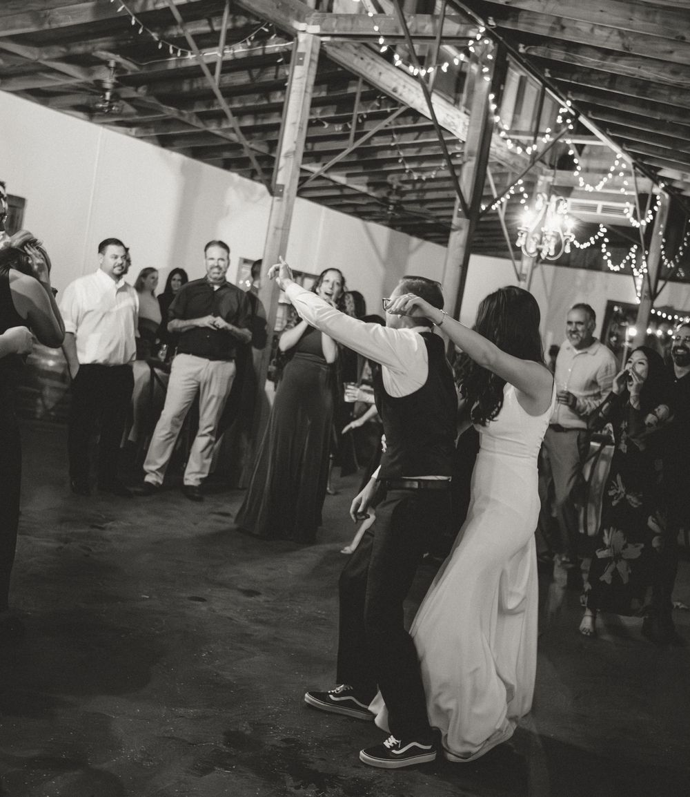 A series of black and white photos showing couples dancing at a wedding reception in an indoor venue.