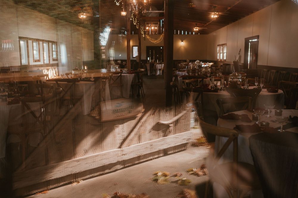 Rustic wedding reception venue with warm lighting and chandeliers creating an intimate atmosphere.