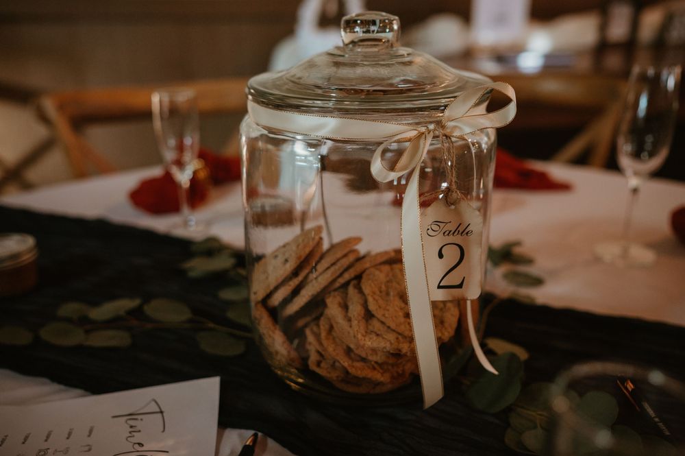 Wedding reception table details with mason jars and rustic decor in warm lighting.