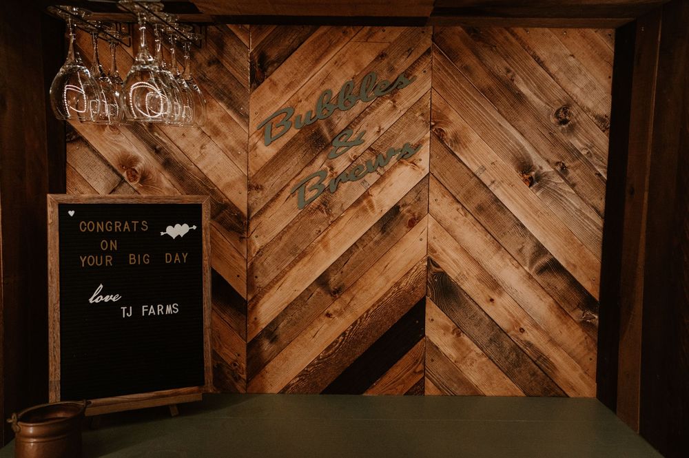 Rustic wooden wall decor with vintage signs and frames creates cozy ambiance at wedding venue.