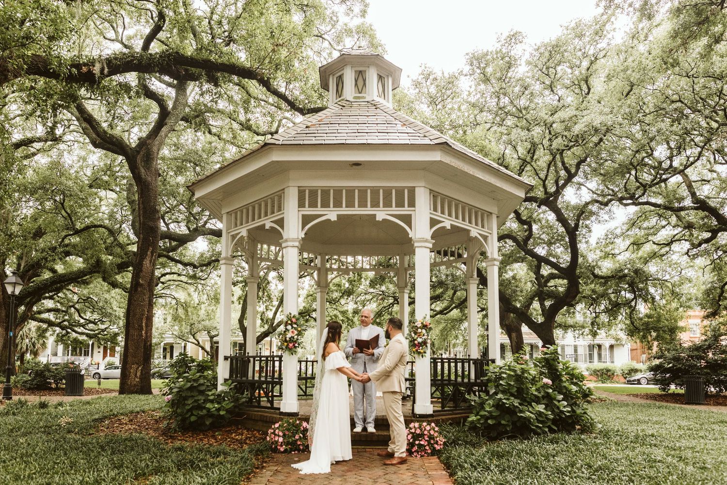 A romantic gazebo wedding in Savannah, GA surrounded by moss-draped oak trees in a serene Southern square setting.