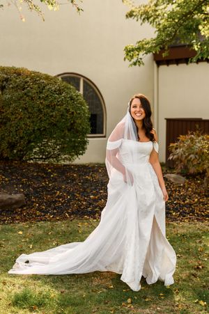 A white wedding dress flows elegantly in the autumn breeze as it is captured in a series of artistic outdoor photos.