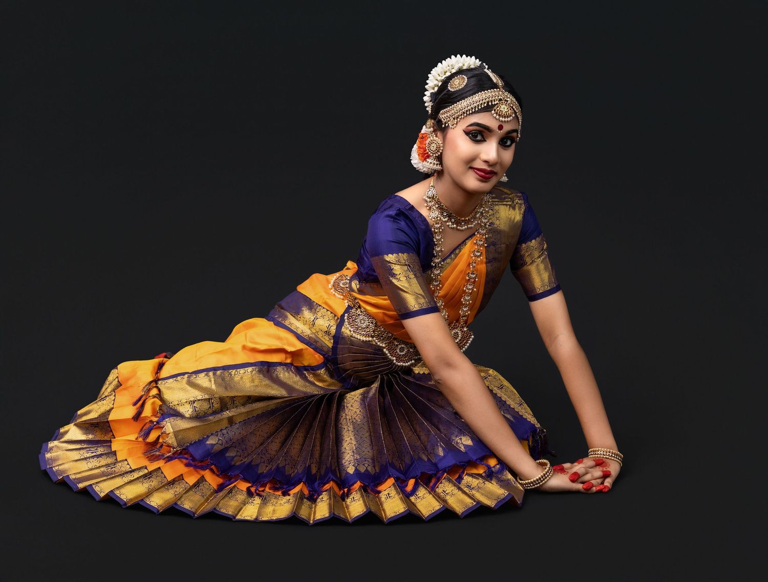 Dancer in vibrant yellow and purple classical Indian dance costume performs graceful poses in a photo collage.