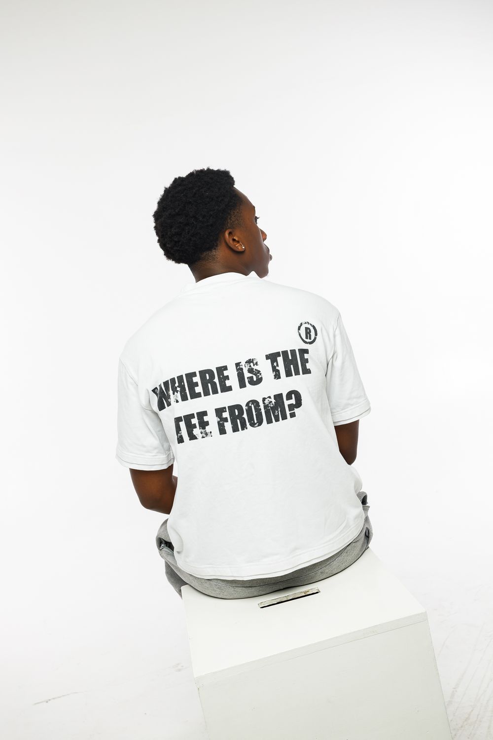 Four views of a white t-shirt with black text displayed on the back against a light background.