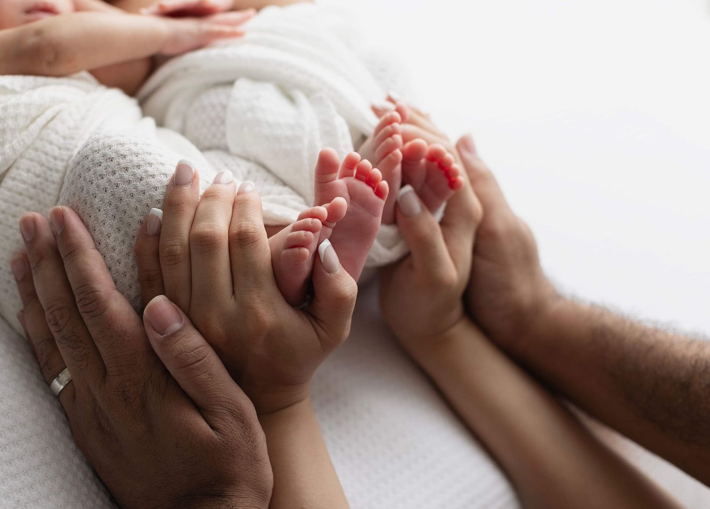 Close-up of massage therapist's hands performing professional massage techniques on white background.