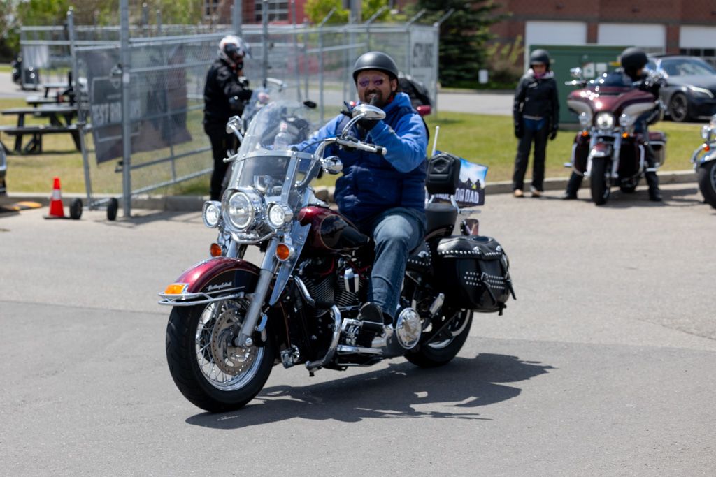 A row of parked Harley-Davidson motorcycles lined up at an outdoor motorcycle event or gathering.