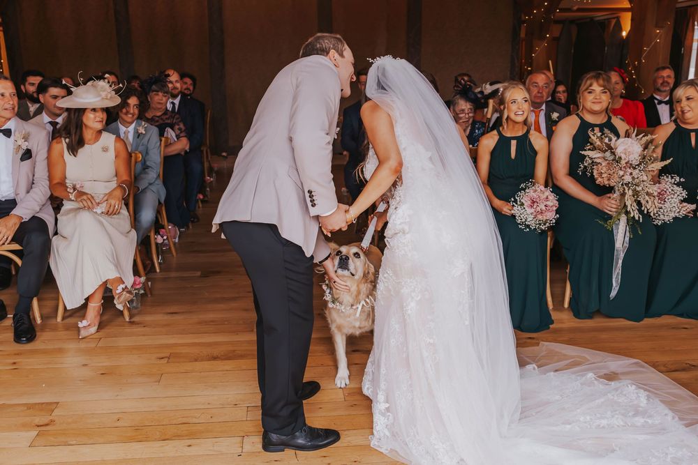 Wedding guests dance and celebrate on a wooden dance floor during a reception party.