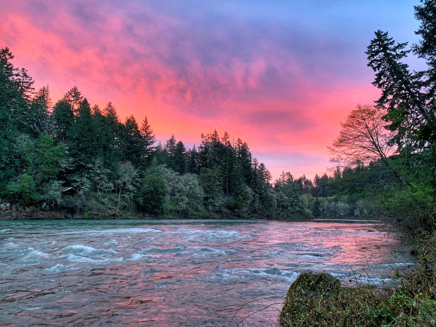 Panoramic sequence of vibrant orange and pink sunset clouds over ocean waves breaking on a sandy beach.