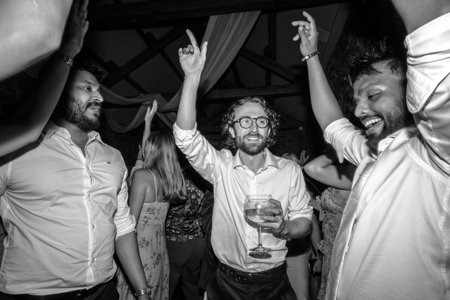 Wedding reception dance party with guests celebrating in black and white.