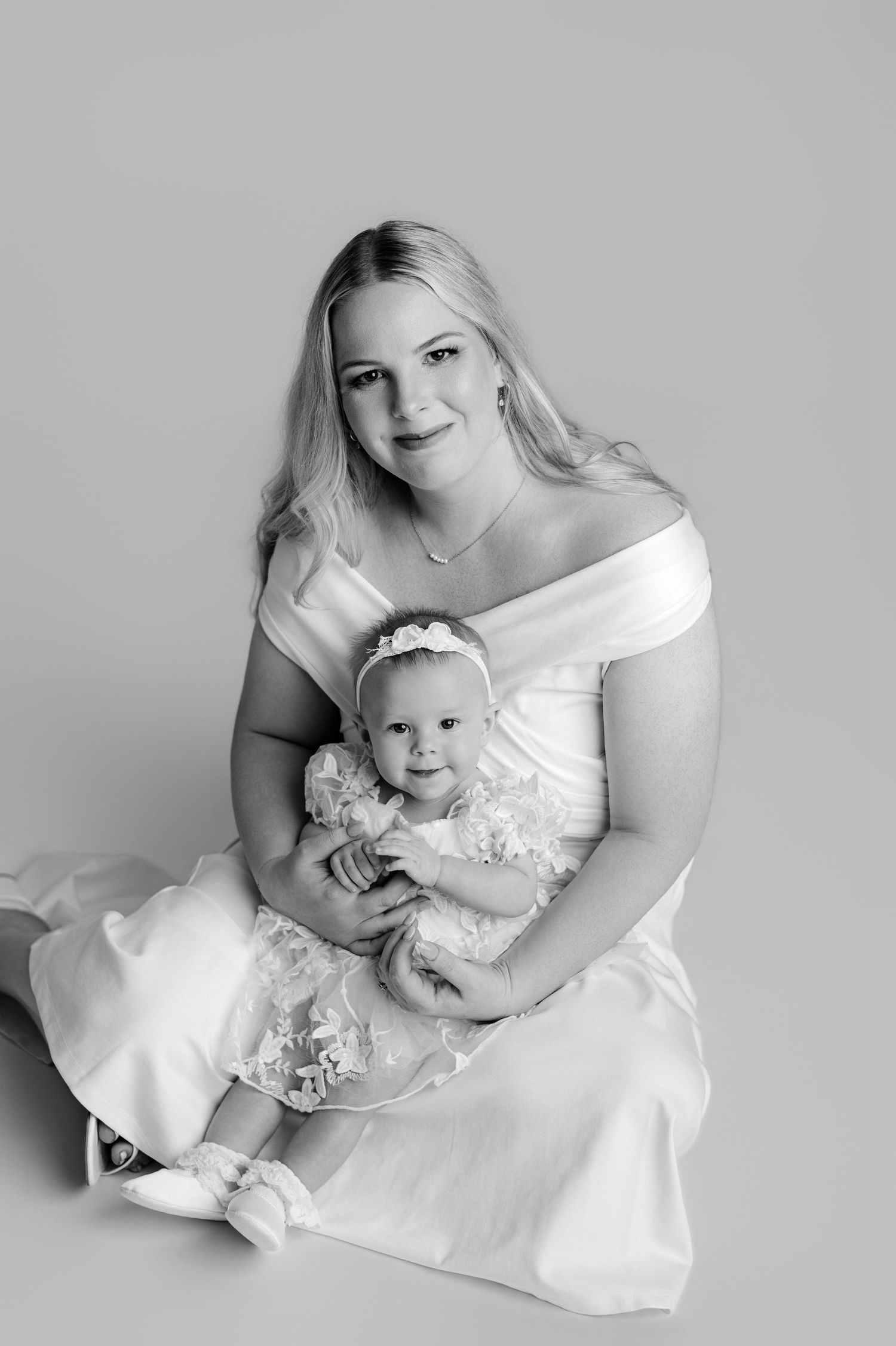 A tender black and white photo series showing a mother in lace dress sharing sweet moments with her small child.