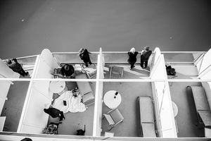 Aerial black and white view of passengers relaxing on a cruise ship deck.