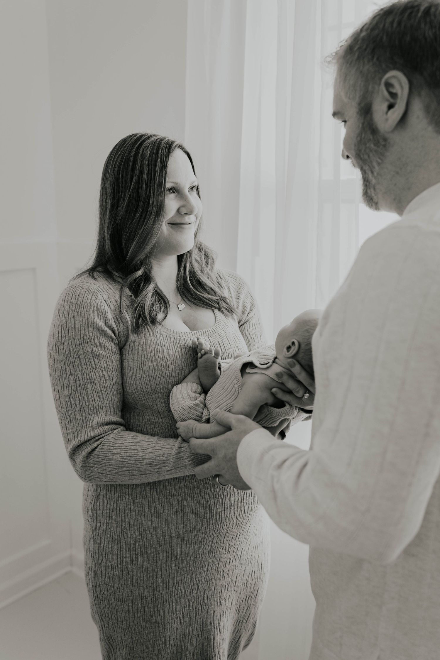 Lakeville MN cozy studio newborn session. Snuggles between mom and dad with newborn baby.