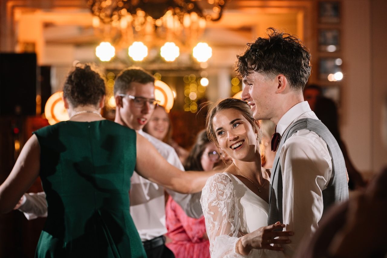 Bride and groom share intimate first dance moment at warmly lit wedding reception.