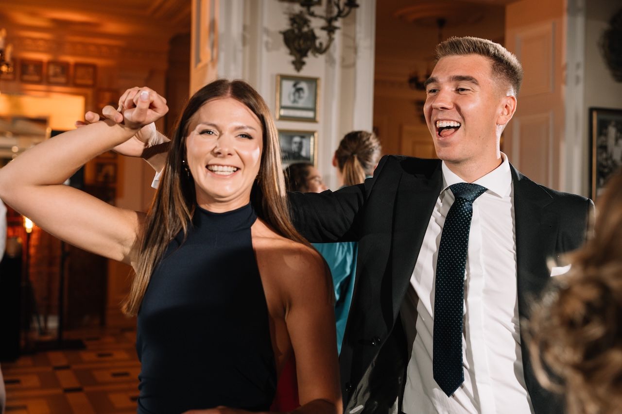 Smiling couple dancing joyfully together at elegant wedding reception celebration.