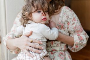 Collection of photos showing a cat and child playing together indoors.