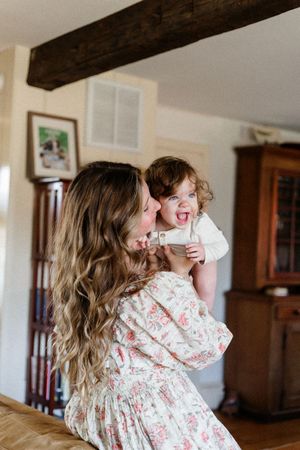 Joyful interaction between parent and child showing playful laughter in a home setting.
