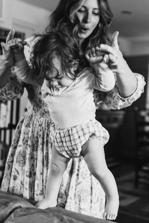 Black and white photos capture playful movement and dancing in a vintage-style dress with ruffled sleeves.