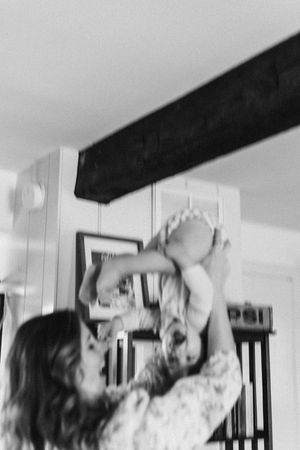A series of black and white photos showing a person lying down and stretching in an interior space with wooden beams.