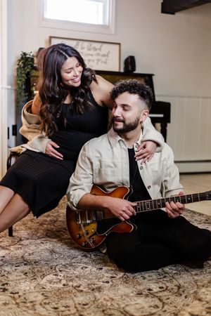 Couple sharing intimate moments while playing acoustic guitar on a granite countertop.