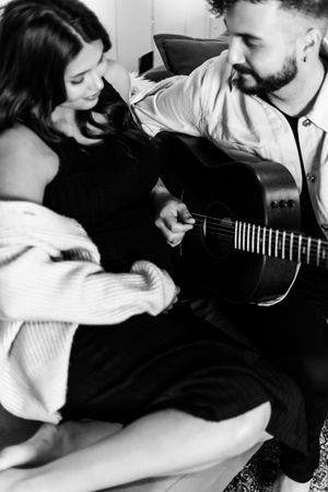 Black and white photo series showing intimate moments of a couple playing guitar and embracing.