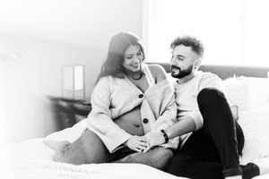 Romantic couple sharing tender moments while lounging on light colored furniture.