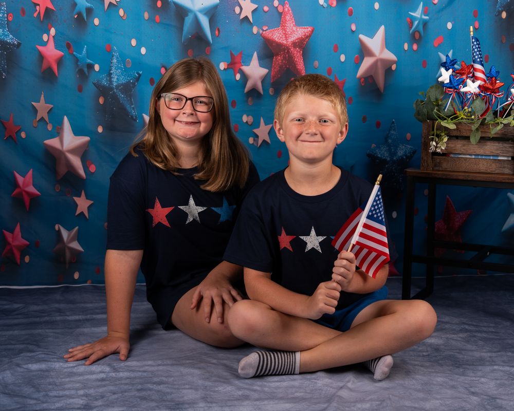Patriotic photo setup with stars and American flag backdrop in red white and blue.