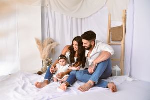 A tender family moment captured in an intimate indoor setting with white decor.