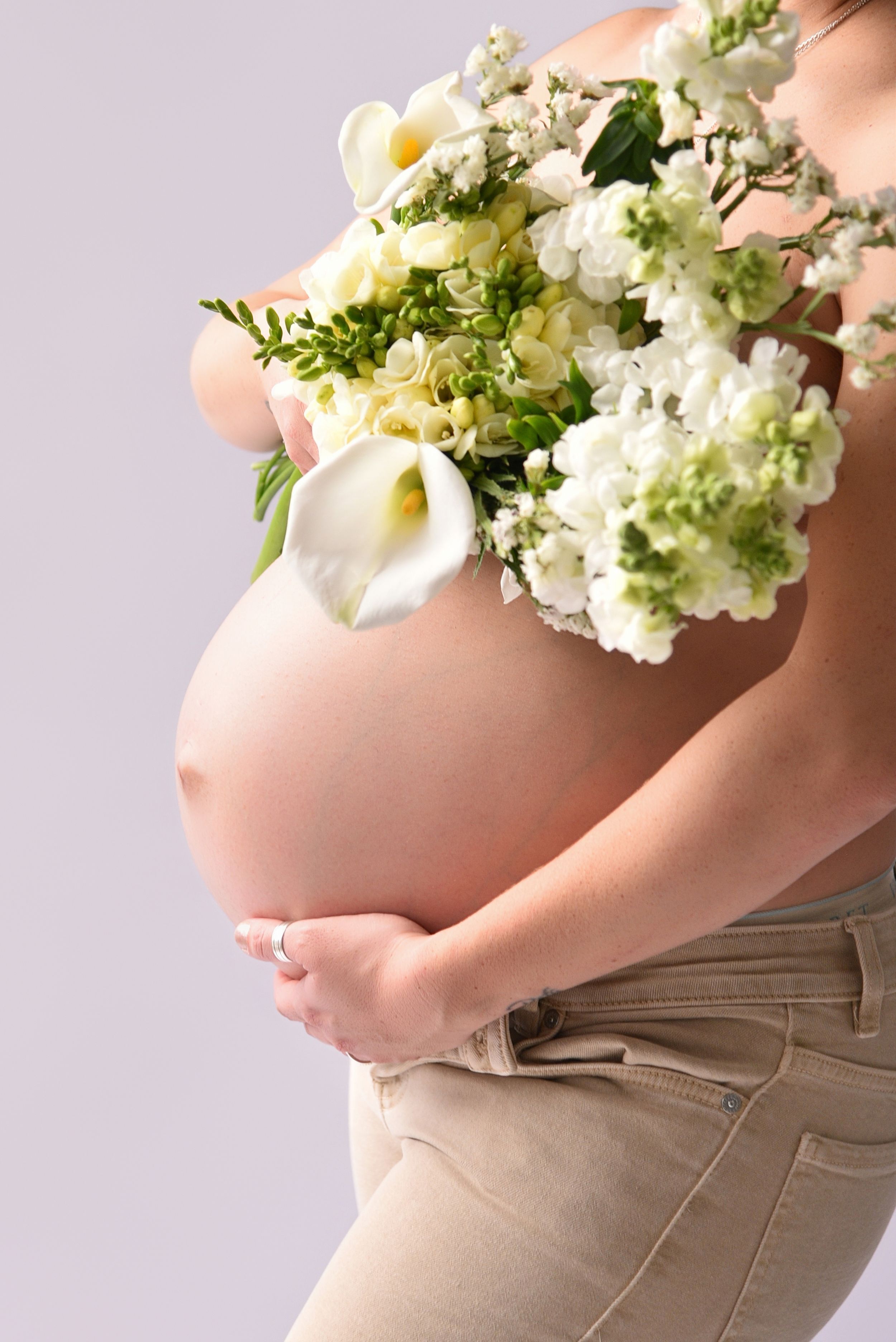 Maternity photo montage showing pregnant belly cradling delicate white and green floral bouquet against soft backdrop.