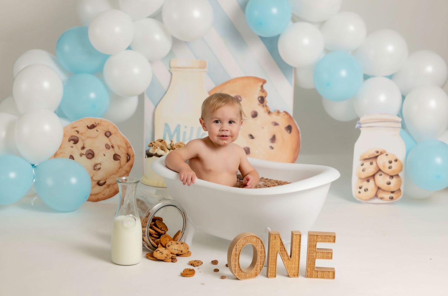One-year-old celebrating with a colorful cake smash session