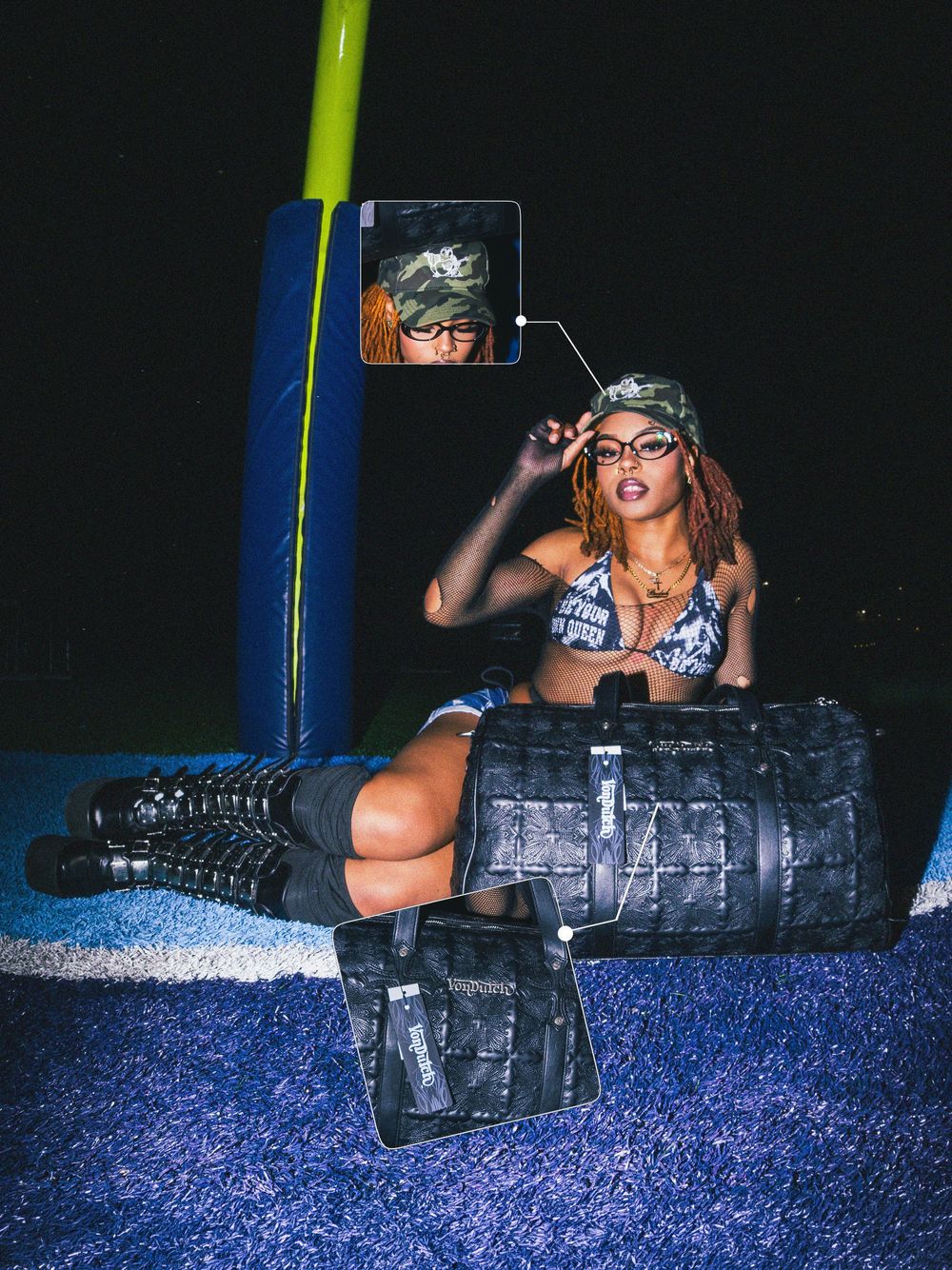 Fashion model in camo and combat boots poses with military style bags on blue carpet in dark studio setting.
