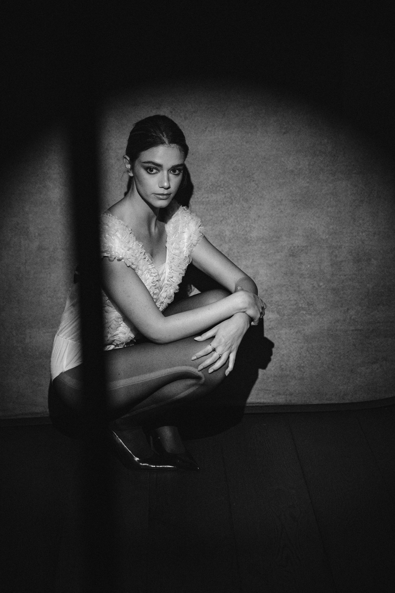 Elegant black and white fashion portrait featuring lace dress and dramatic shadows.