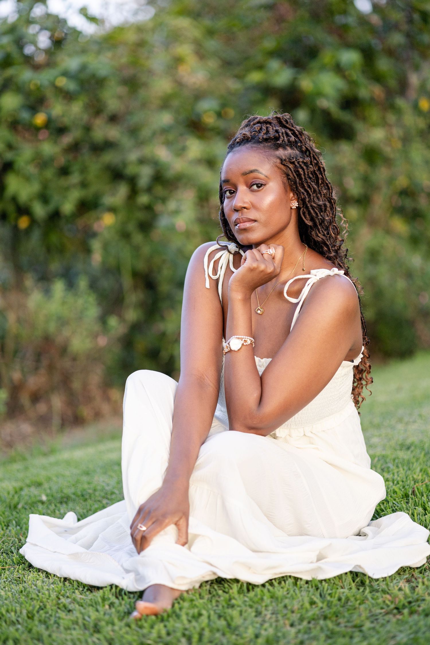 Full-length portrait of a lady in Naiposha Gardens. She sitted, holding her ankle, chin resting on other hand. Ikigu George Photography.