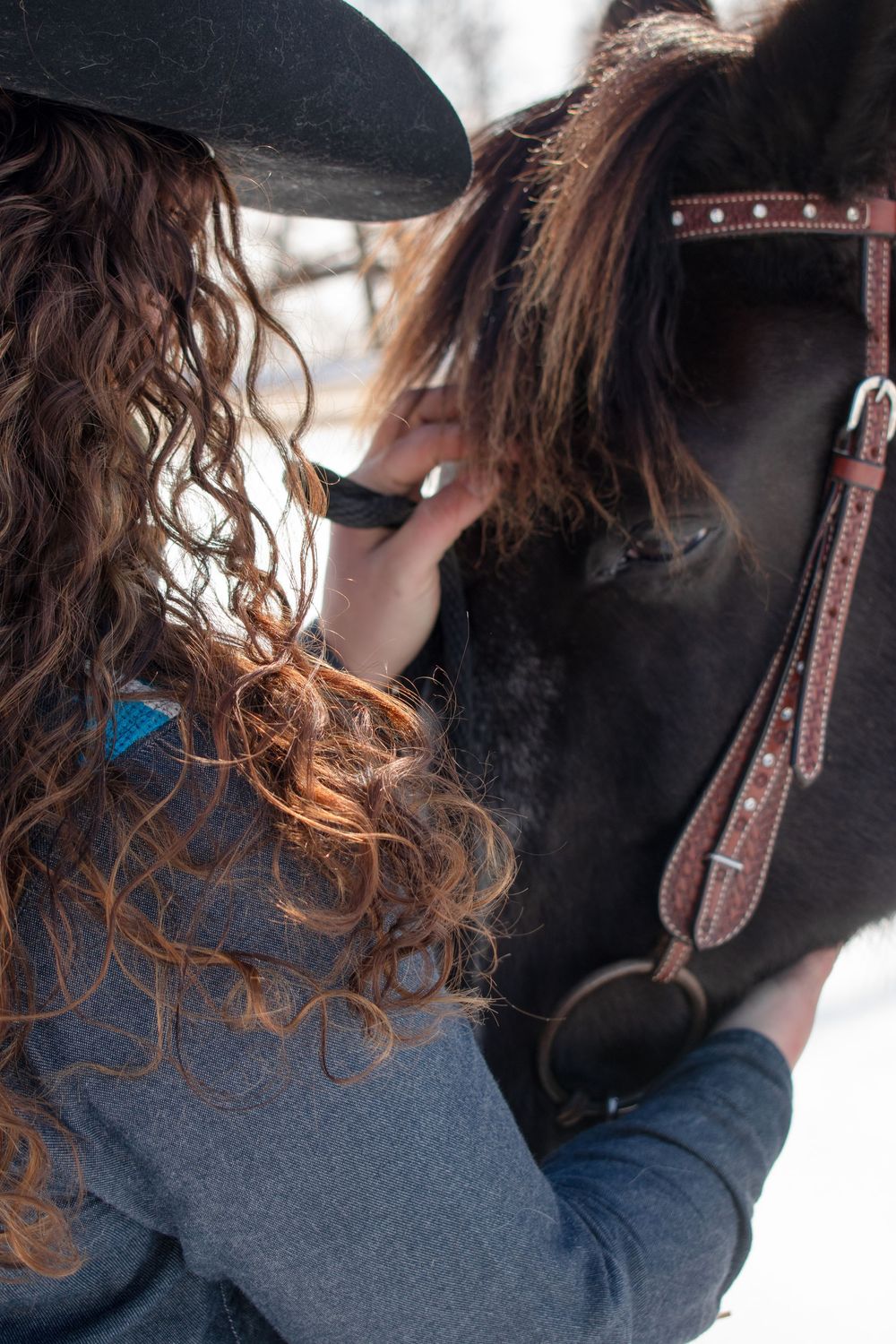 Cowgirl scratching her horse's head in a Wisconsin winter scene