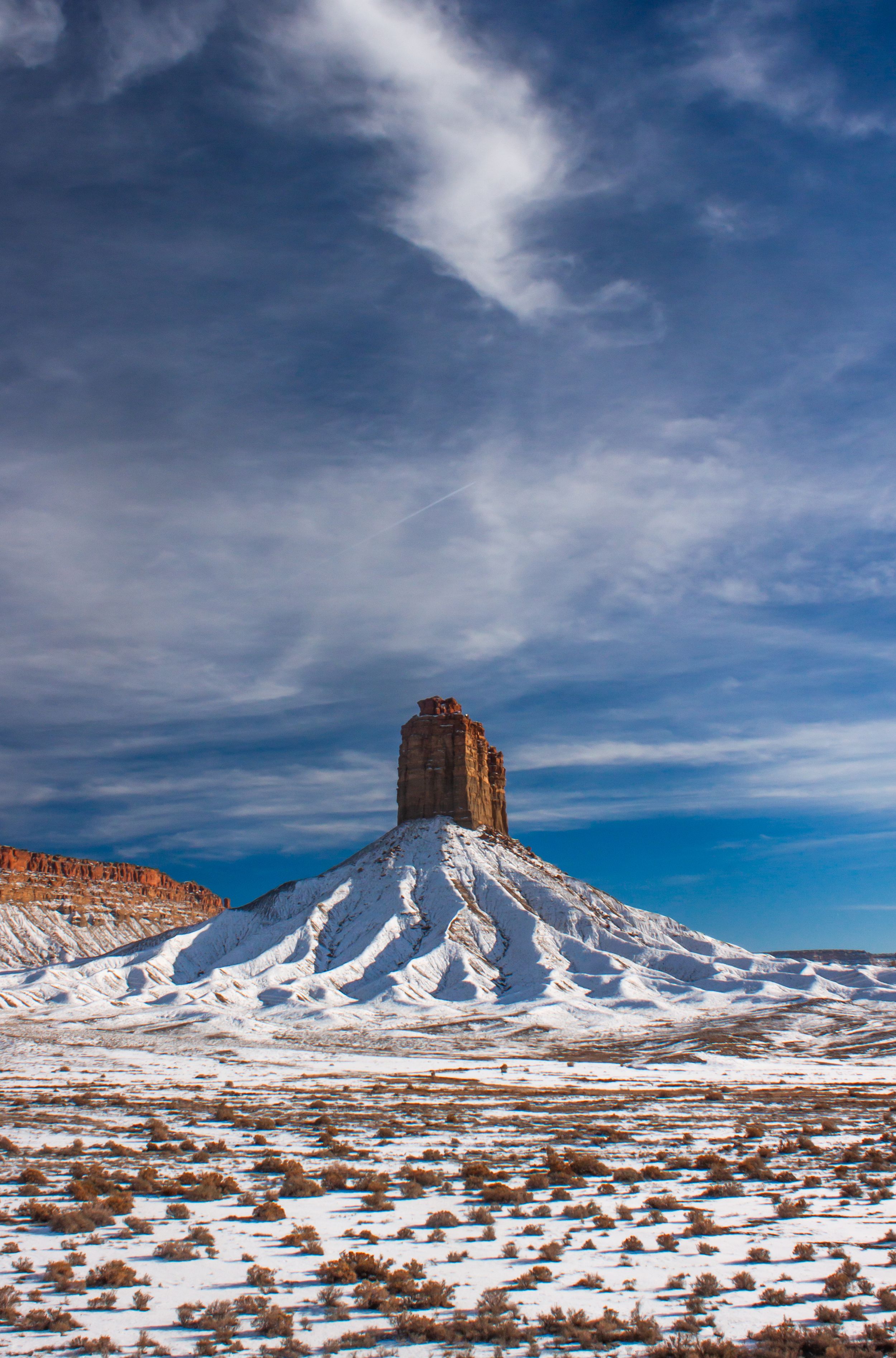 Fine art landscape photograph of a red rock desert monument in the four corners region of Arizona covered in snow. Wall art.