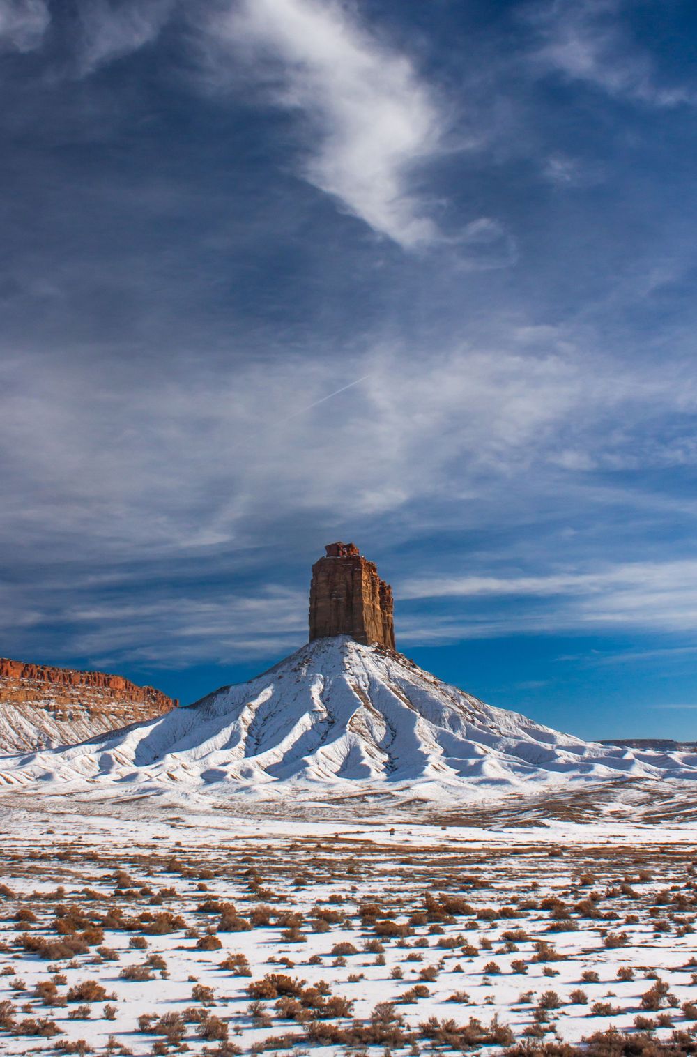 Fine art landscape photograph of a red rock desert monument in the four corners region of Arizona covered in snow. Wall art.