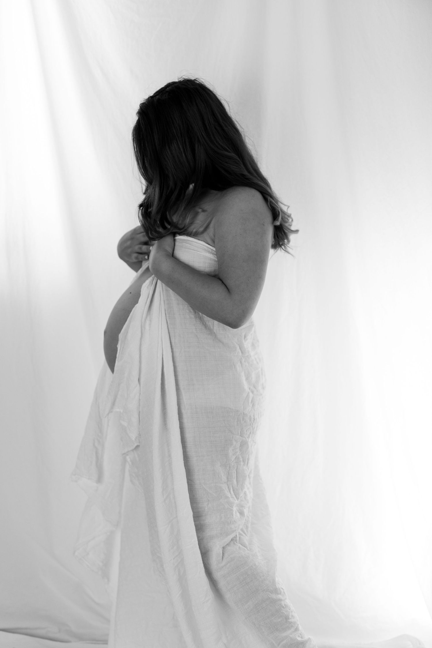 Artistic black and white portrait series showing ethereal movement with flowing white fabric.