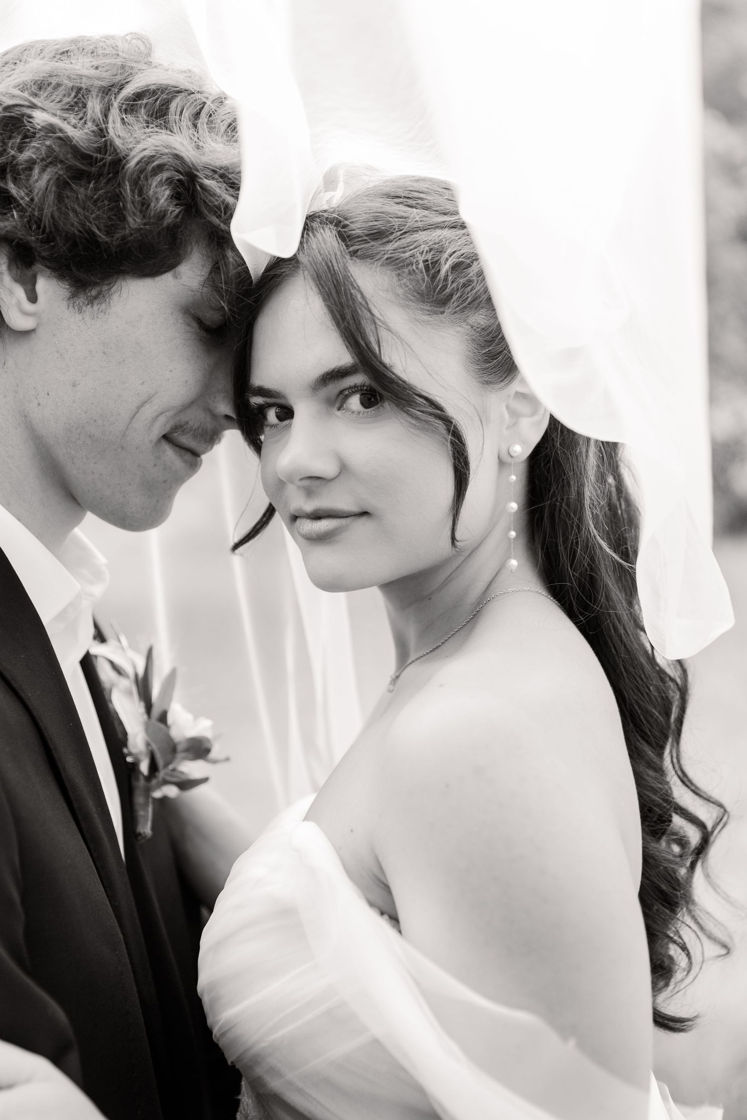 Intimate black and white wedding portraits captured in soft, romantic lighting.