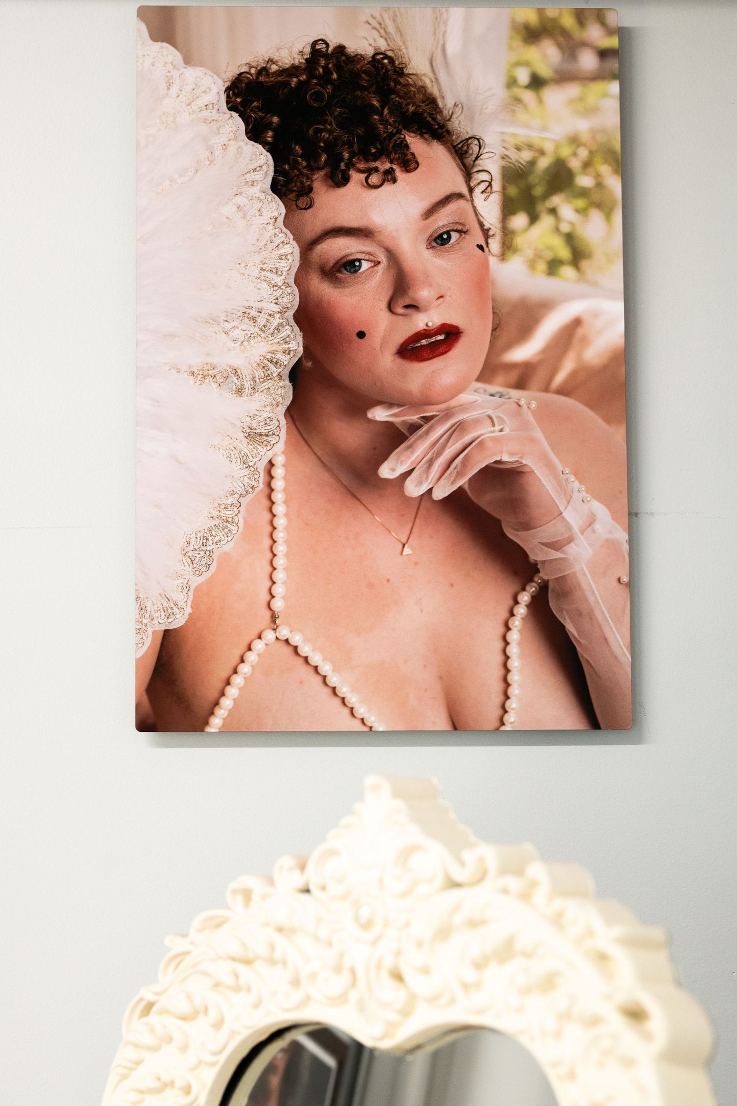 A romantic boudoir photoshoot with soft lighting, pearl necklace and delicate lace details in warm tones.