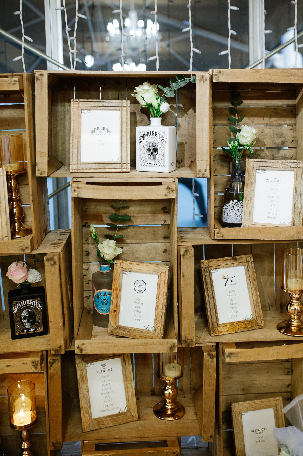 Rustic wooden wall display with vintage frames and hanging Edison bulbs creating a warm, cozy atmosphere.