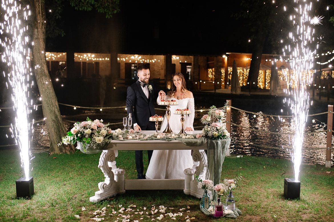 Outdoor wedding celebration with sparkler fountains creating a magical nighttime atmosphere.