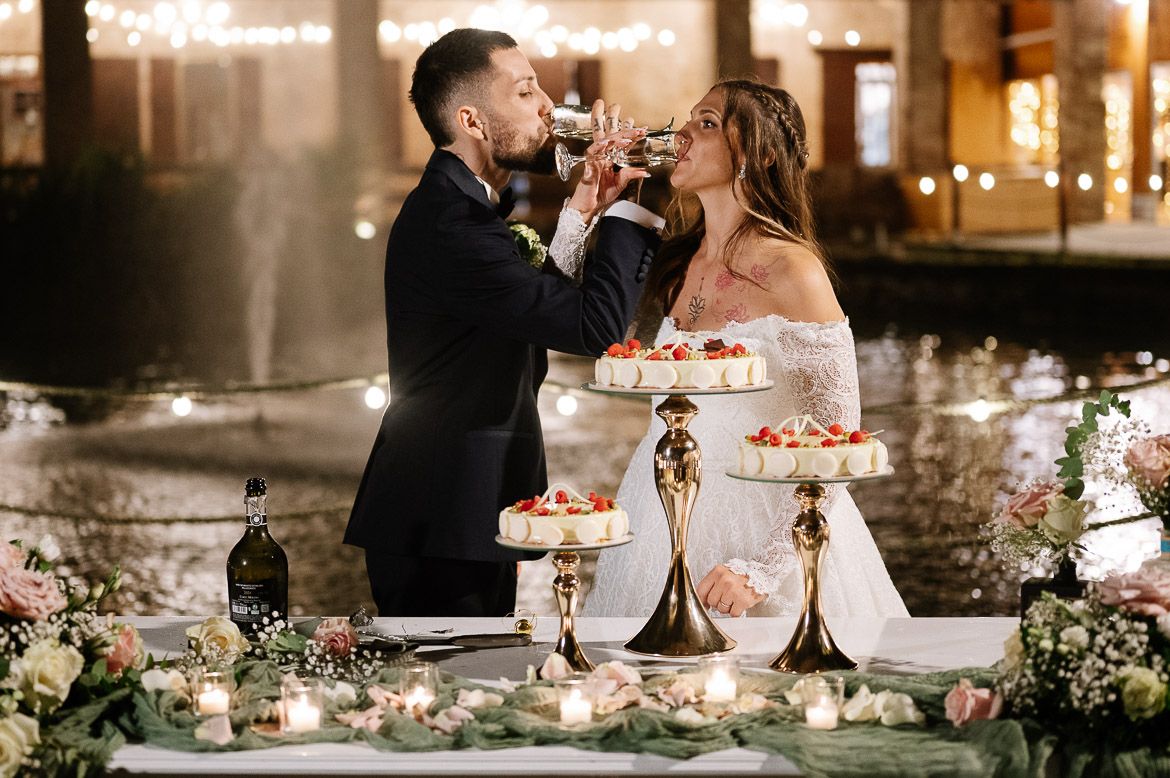 A romantic wedding reception scene with string lights and floral decorations adorning an elegant table setting.