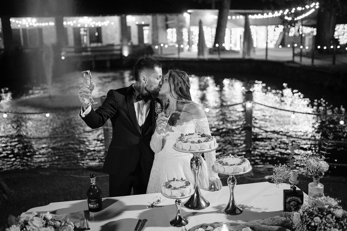 A black and white photo of a wedding reception with string lights and elegant table settings.