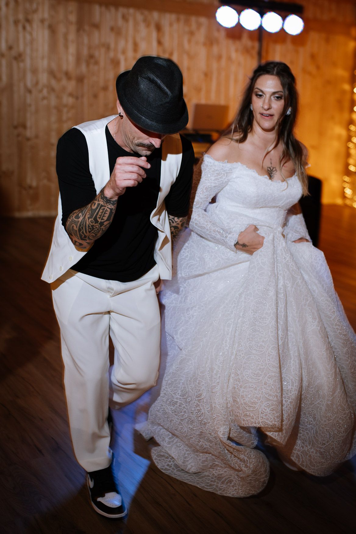 Close-up of wedding dress details during a dance move on wooden floor.