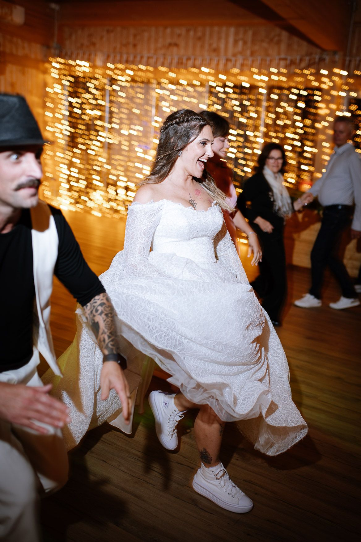 Dynamic dance floor shots capture wedding guests spinning and twirling in a festive atmosphere.