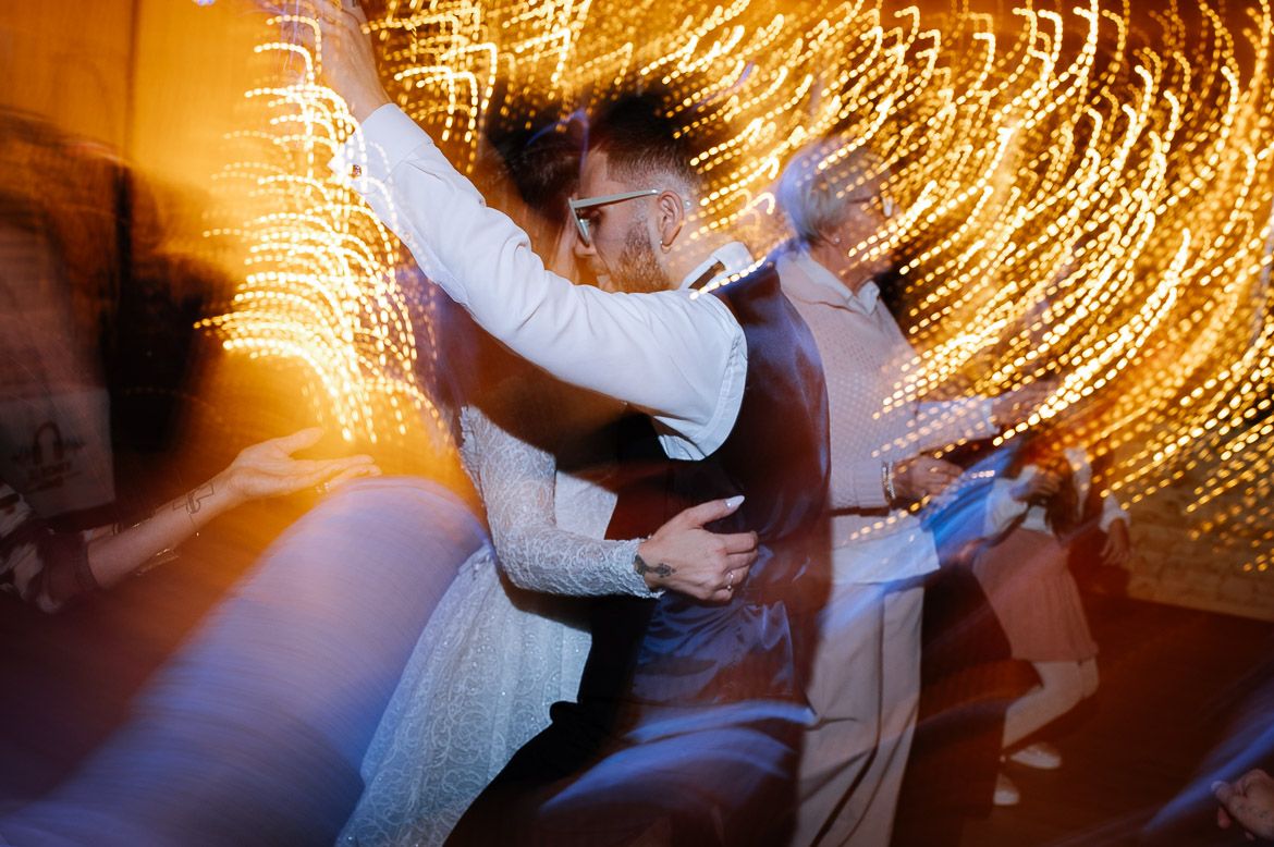 Dancing couple spins on dance floor with golden light trails creating a magical swirling effect in the background.