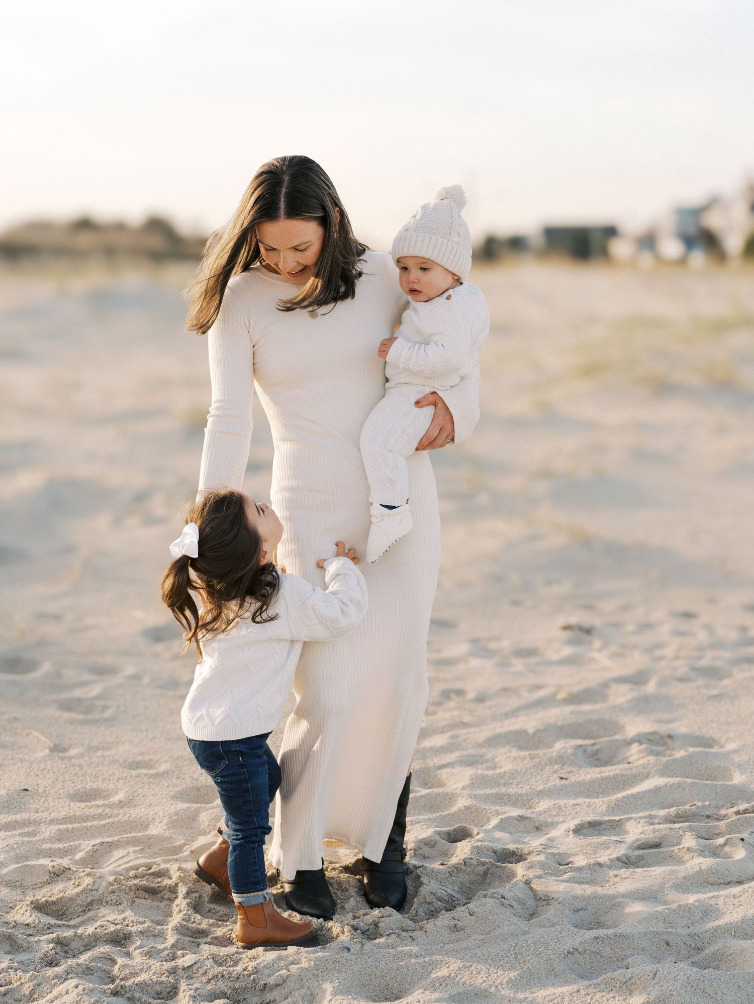 Natural family interaction captured with a mother and her two children during a Monmouth County fall beach session.