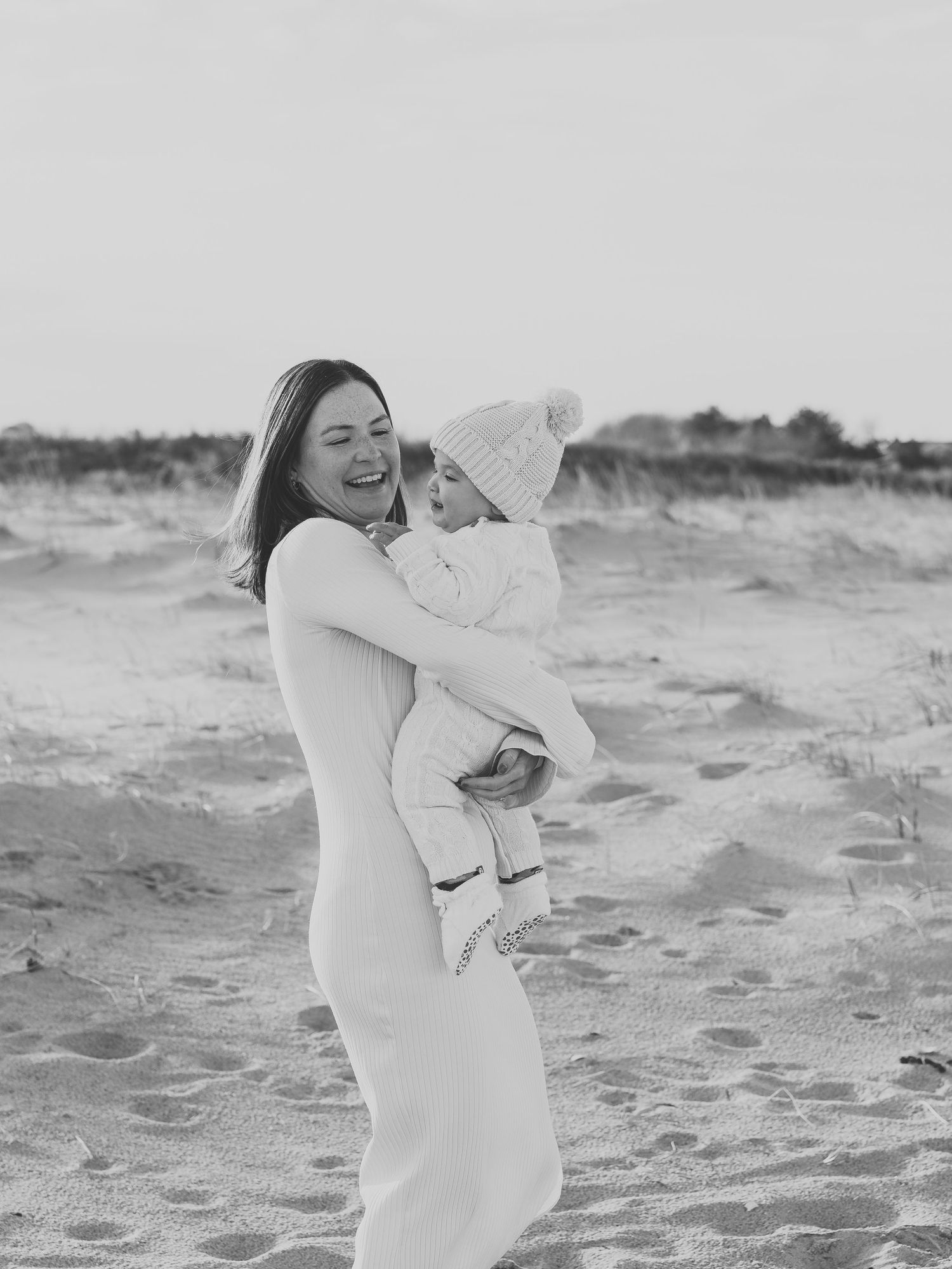 Mother plays with her son on the beach while Lauren Marie Photography captures the loving moments.