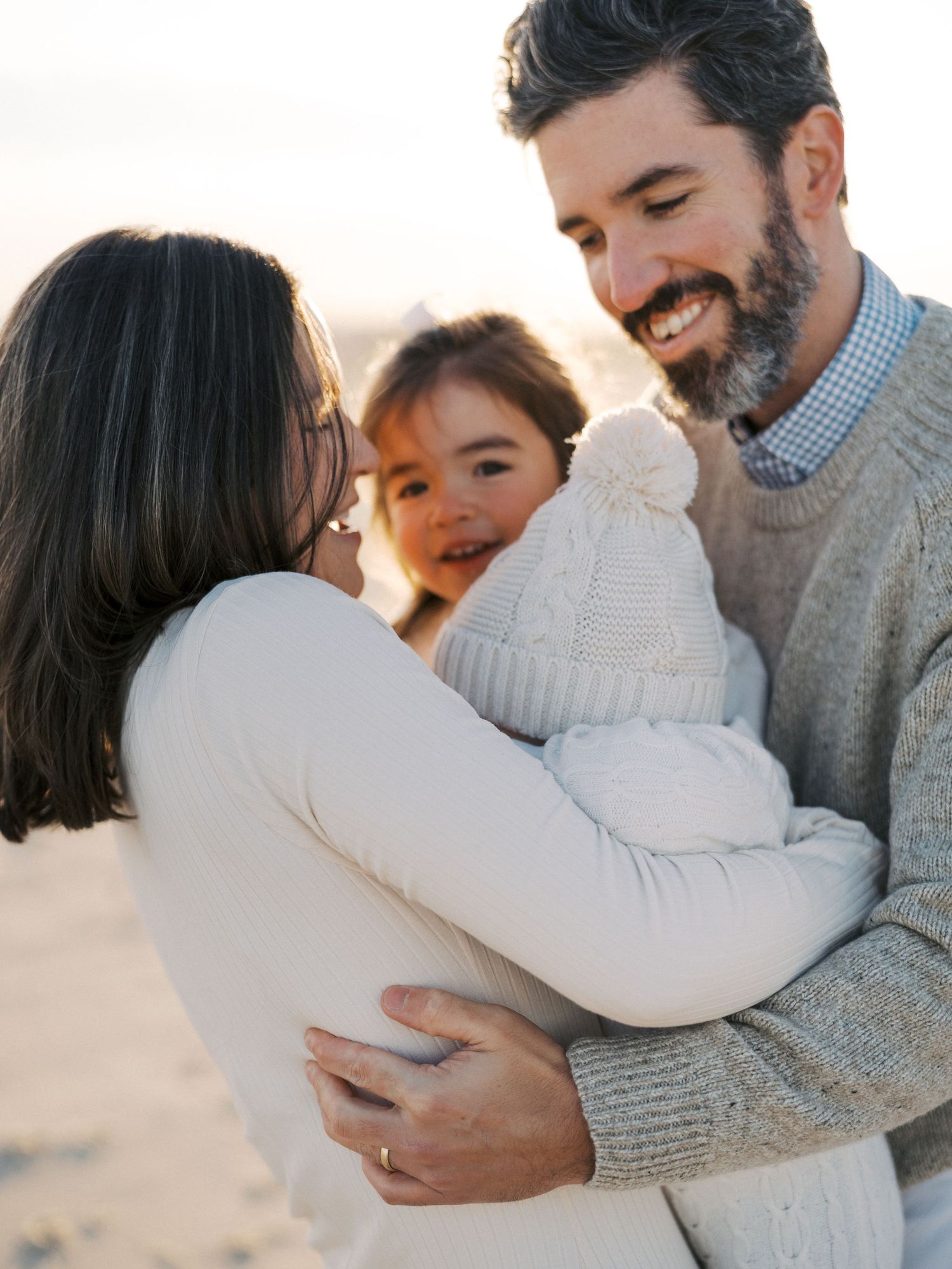 Close-up of parents holding their children during a fall beach photography session in Monmouth County.