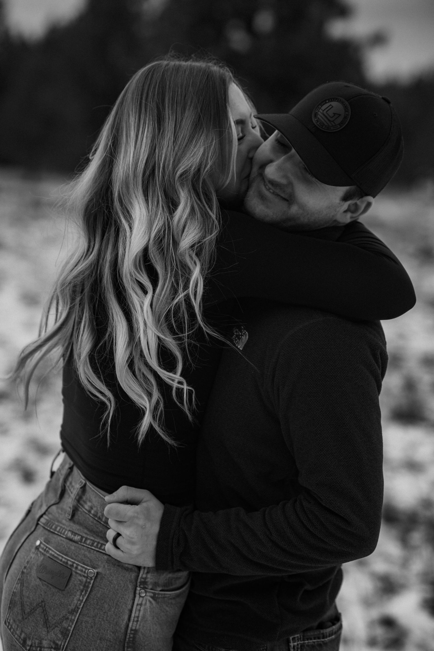 A romantic black and white photo series showing a couple embracing and sharing intimate moments in casual denim attire.