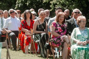Wedding guests in colorful attire seated outdoors for a summer garden ceremony. Hayne, Devon